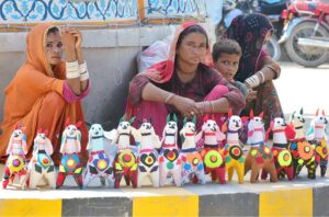Women displaying cloth made toys to attract the customers on the roadside.