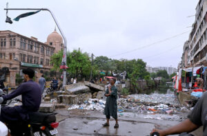 Vehicular traffic moves accumulated rain water on a Tower area during monsoon rain in the metropolitan.