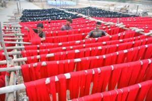 Workers busy in drying fabric thread on bamboos.