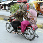 Women motorcyclists head towards their destination in the provincial capital city