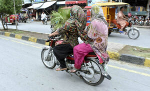 Women motorcyclists head towards their destination in the provincial capital city