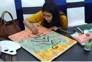 Art student engages in calligraphy along with painting during art classes at the summer camp at Alhamra Arts Council Academy in Provincial Capital.