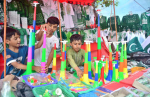 Young vendors showcase national flags and festive items, capturing the attention of patriots for the upcoming Independence Day celebrations.