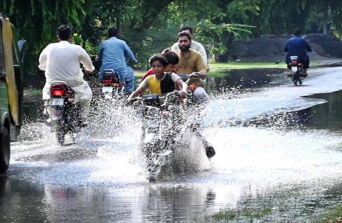 After heavy rains in the provincial capital, young motorcyclists are splashing water all around while passing through the water