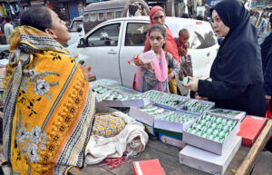 A woman vendor sells bangles and other items at her stall as the nation gears up for Independence Day celebrations.