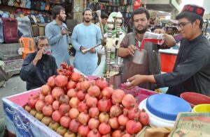 A roadside vendor prepares pomegranate juice for customers.