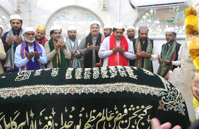 Acting Governor Punjab Malik Ahmad Khan is praying at the Shrine of Data Darbar after placing the Charad