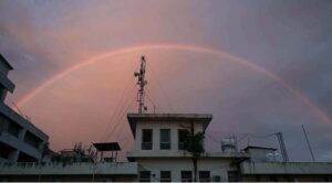 An eye catching view of rainbow appear over the city at sunset time.