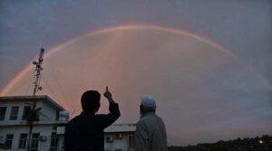 An eye catching view of rainbow appear over the city at sunset time.