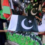 Vendor displaying national flag caps and other celebration stuff to attract the customers in connection with upcoming Independence Day celebrations
