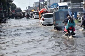 Vehicles and bikers make their way through heavy rain at Kotli Behraam .