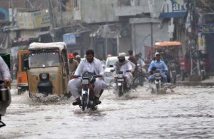 Vehicles passing through rainwater accumulated on the Masoom Shah road after heavy monsoon rain in the City.
