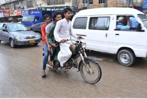 Motorcyclist on the way during Light Monsoon Rain in some areas of the City.
