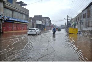 Vehicles passing through rainwater accumulated on the Masoom Shah road after heavy monsoon rain in the City.