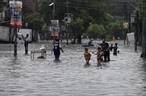 People ride a horse cart through a flooded road during rain that experienced in Provincial Capital.