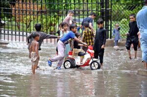 Children playing in rain water accumulated at Jinnah Bagh.
