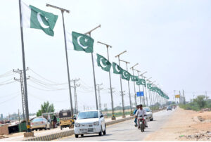 Youngsters riding bicycles with national flags to express their love while celebrating Independence Day at Latifabad.