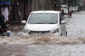 People ride a horse cart through a flooded road during rain that experienced in Provincial Capital.