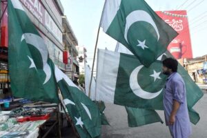 A girl proudly shows her love for her motherland by hoisting the national flag on a moving car.