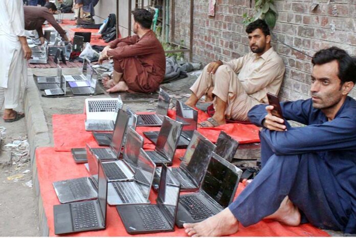 A street vendor displayed used laptops at low prices, attracting customers on his footpath setup in the provincial capital