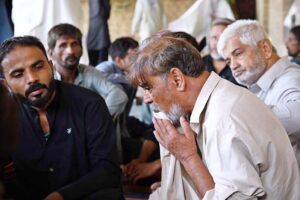 Relatives in mourning and grief gather at Shamsi Imambargah, deeply affected by the recent bus crash in Iran that claimed the lives of their loved ones.