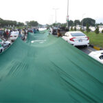 People having huge national flag marching on Islamabad Expressway to celebrate the Independence Day of Pakistan