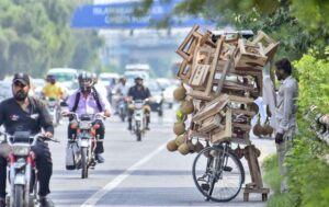 A street vendor waits for customers by displaying a wooden stool and a bird's nest on his bicycle to attract customers in Shukar Parian