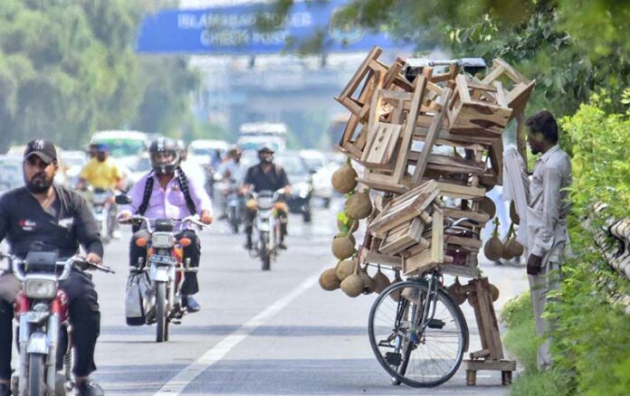 A street vendor waits for customers by displaying a wooden stool and a bird's nest on his bicycle to attract customers in Shukar Parian