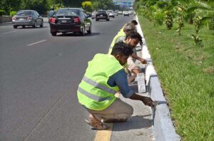Workers busy repairing cemented blocks at center path of Islamabad Highway