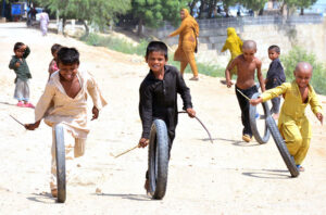 Children enjoy playing with motorcycle tyres at Shoro Goht area