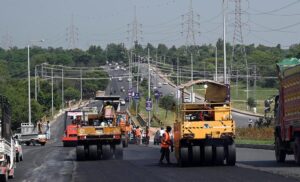 Labourers busy in road construction with the help of heavy machinery during development work near Faizabad.