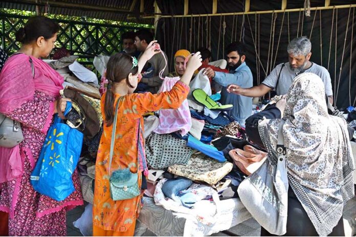 People selecting and purchasing bags from stall at weekly Sunday Bazaar, Aabpara