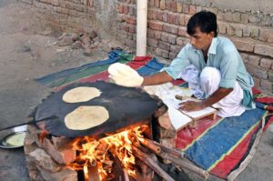 A person busy in preparing bread in the street for the wedding guests near New Bus Stand Road