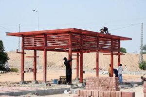 Labourers busy preparing a Blue bus terminal on Islamabad Expressway.