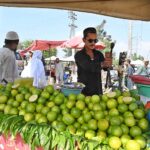 A vendor is extracting green orange “metha” juice at his setup in the Sunday Bazaar, Aabpara