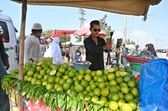 A vendor is extracting green orange “metha” juice at his setup in the Sunday Bazaar, Aabpara
