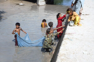 Children busy in fishing in traditional way at a canal near new bas stand.