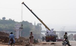Heavy machinery being used to install a pedestrian bridge on Islamabad Expressway.