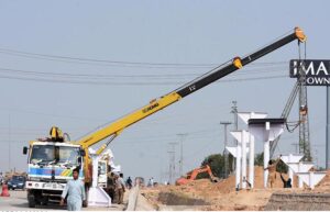 Heavy machinery being used to install a pedestrian bridge on Islamabad Expressway.