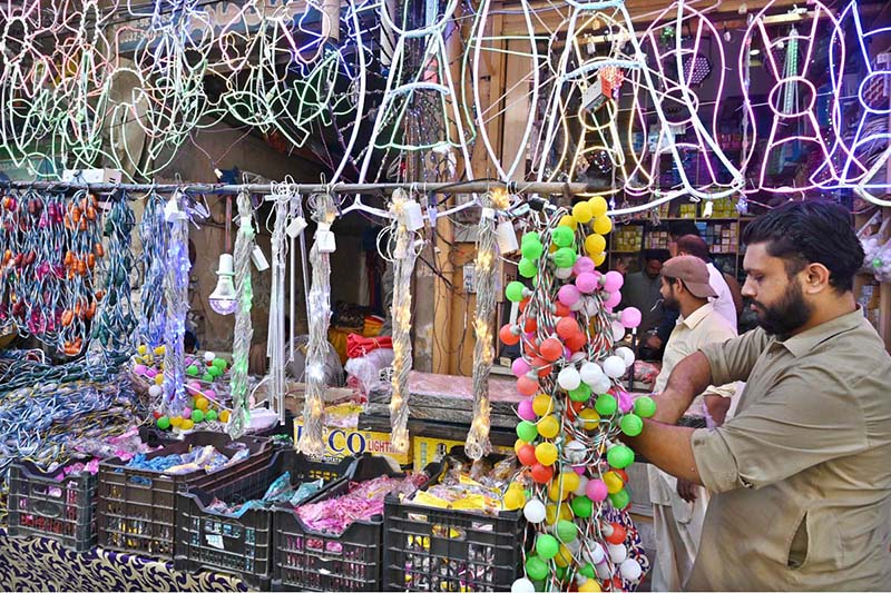 A vendor at Bani Road presents a dazzling variety of colorful lights to attract customers