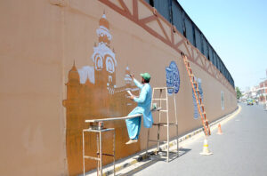 Skilled workers painting on the flyover Bridge wall at Kalma Chowk.