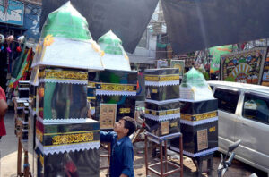 A shopkeeper displays wooden models of Roza-e-Rasool , Khana Kaba and decorative items on the holy occasion Eid Milad-un-Nabi (PBUH) to attract customers in the provincial capital.