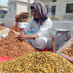 A vendor displaying dry fruit at his roadside setup on the footpath to attract customers