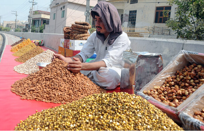 A vendor displaying dry fruit at his roadside setup on the footpath to attract customers