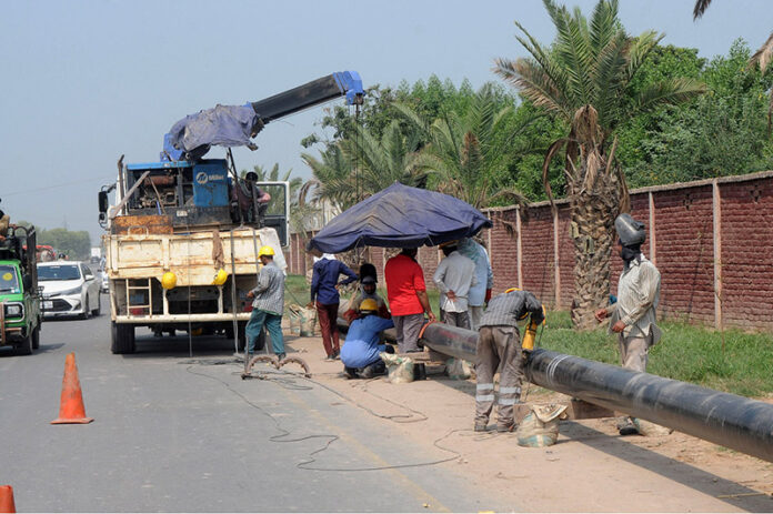 SNGPL staffers laying gas pipeline on Sher Shah Road