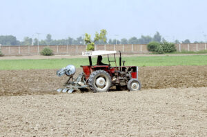 A farmer is preparing his field with the help of a tractor for the next crop.