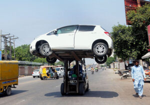 A traffic warden uses a forklift to remove a wrongly parked vehicle, ensuring smooth traffic flow and preventing any obstruction at LMQ Road.