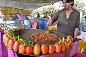 A vendor busy preparing traditional food item “Kaleeji” at his setup in Pirwadhai.