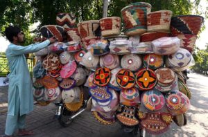 A vendor selling beautiful traditional kitchen handcraft items on his bike at roadside.