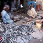 An artisan crafting Kulfi molds in his workplace at Shalini Chowk
